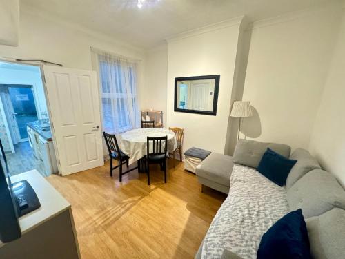 a living room with a couch and a table at 4 Bedroom House in Turnpike Lane/Wood Green in London