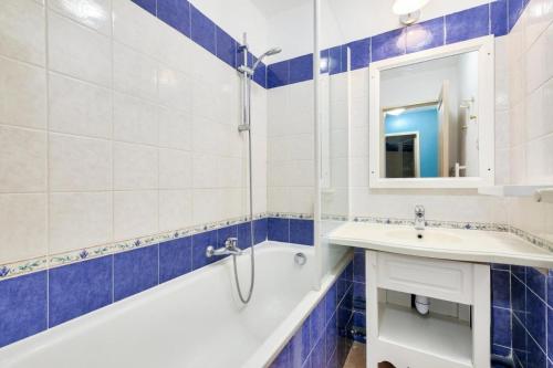 une salle de bain avec une baignoire, un lavabo et un miroir dans l'établissement Résidence le Hameau des Issambres - maeva Home - Appartement 3 Pièces 7 Personnes - Prestige MAE-4534, aux Issambres