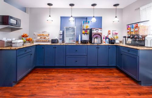 a kitchen with blue cabinets and wooden floors at Casco Bay Inn in Freeport