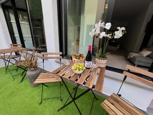 uma mesa com uma taça de fruta e uma garrafa de vinho em Sorolla Urban Suites em Valência