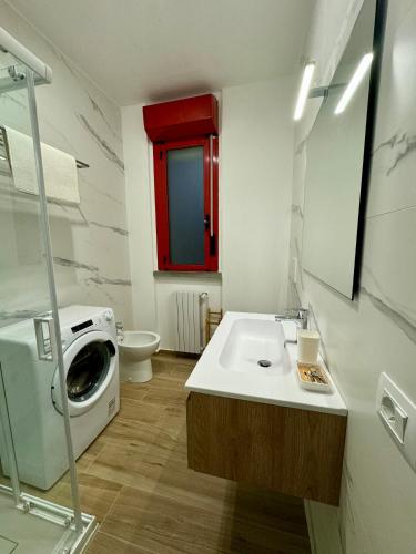 a bathroom with a washing machine and a sink at L’armadio di Narnia in Alzano Lombardo