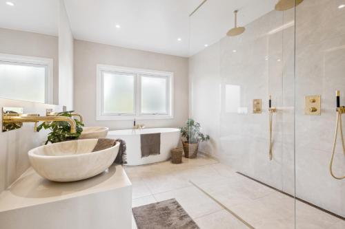y baño con bañera, lavamanos y ducha. en Luxury house with 5 bedrooms close to Oslo Centrum, en Lorenskog