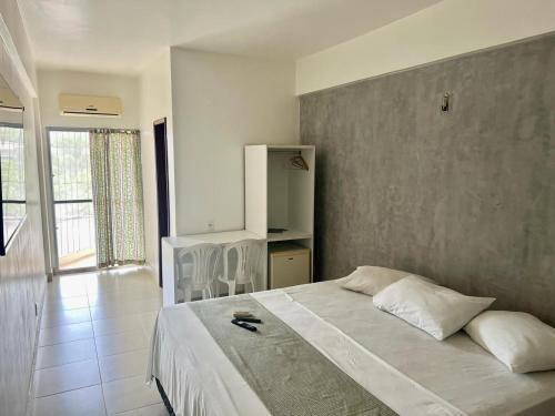 una camera da letto con un letto grande e una grande finestra di Hotel New Tokyo a Capitão Poço