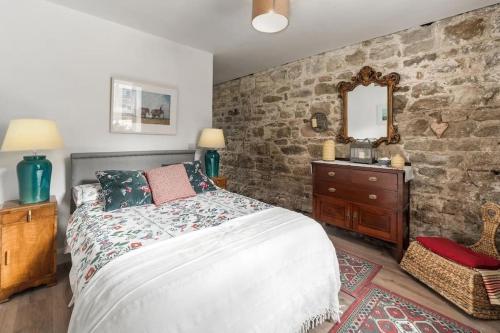 a bedroom with a bed and a stone wall at Stunning Granite Barn Conversion in Tullow