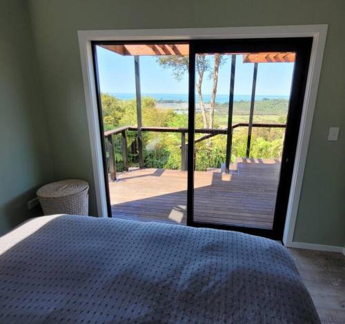 a bedroom with a bed and a view of the ocean at Golden Bay Heights - Luxury Accommodation in Parapara 