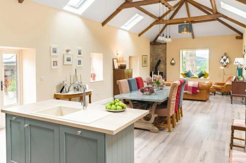 a kitchen and living room with a table and a dining room at Stunning Granite Barn Conversion in Tullow