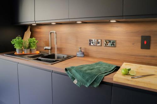 a kitchen with a sink and a wooden counter top at Number1Townhouse with private balcony & Parking in Glasgow