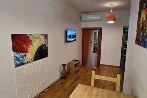 - un salon avec une table et une télévision murale dans l'établissement Setúbal RP House apartamento perto do mar e comércio na Luisa Todi, à Setúbal