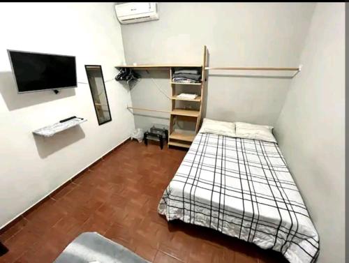 a small room with a bed and a tv at Habitación equipada in Bacurimi