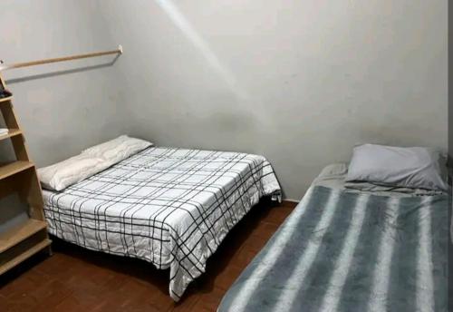 um quarto com duas camas e uma prateleira em Habitación equipada em Bacurimi