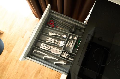 a drawer with scissors and other utensils in it at Cartea Apartments Zürich Airport in Opfikon