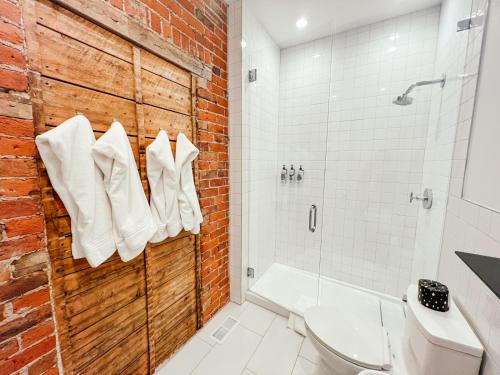 een badkamer met een douche, een toilet en een bakstenen muur bij The Timberline in Leadville