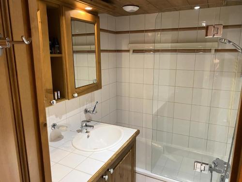 W łazience znajduje się umywalka, prysznic i wanna. w obiekcie Résidence La Ginabelle - maeva Home - Appartement 3 pièces 6 personnes - Sélection MAE-2964 w Chamonix-Mont-Blanc