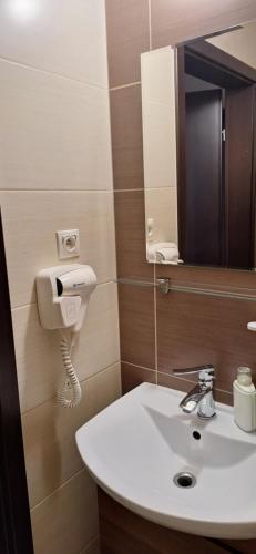 a bathroom with a white sink and a mirror at Hotel Graal Targowisko in Targowisko