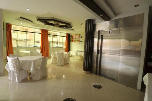 un restaurante con mesas y sillas blancas y una puerta de cristal en Hotel Frontera, en Tacna