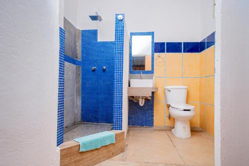 カンクンにあるCasa Playa Hermosaの青いタイル張りのバスルーム(トイレ、シンク付)