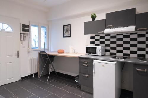 a kitchen with a counter with a microwave at Lovely studio on courtyard in Paris in Paris