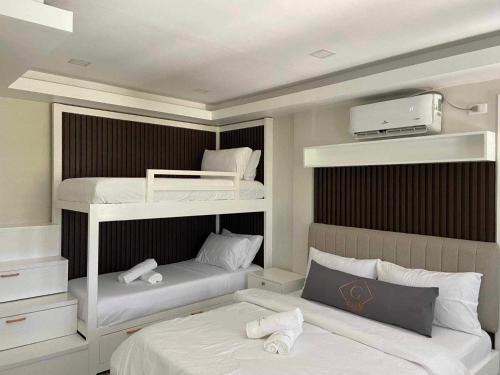 a bedroom with two bunk beds with white sheets at Grospe Resort Boracay in Boracay