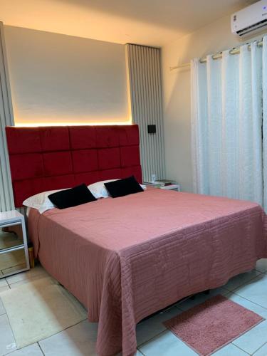 um quarto com uma cama grande e uma cabeceira vermelha em Casa espaçosa e aconchegante em Luís Eduardo Magalhães