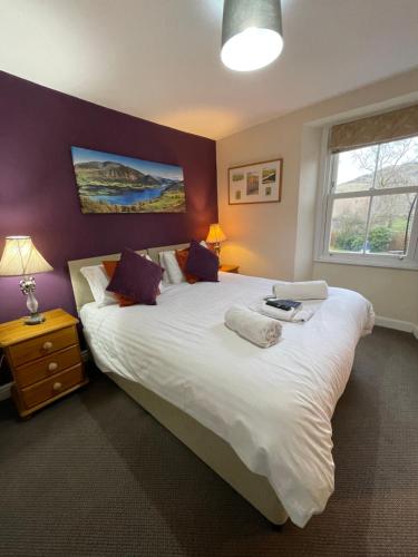 a bedroom with a large bed with a laptop on it at Royal Hotel in Dockray