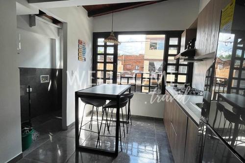 uma cozinha com balcão e bancos de bar em Loft Central cerca de El Poblado em Itagüí