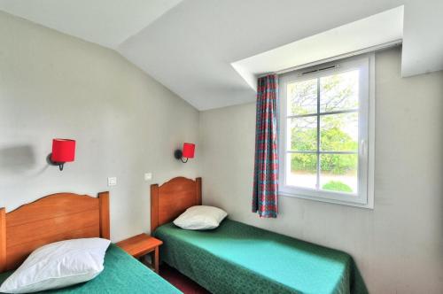 deux lits dans une petite pièce avec une fenêtre dans l'établissement La résidence du Lac - maeva Home - Maison 3 pièces 6 personnes - Sélection MAE-4414, à Monflanquin