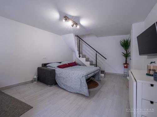 a small bedroom with a bed and a staircase at Maison triplex 6 personnes près de Disney et Paris in Montévrain