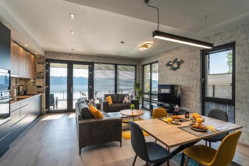 a kitchen and living room with a table and chairs at Duna Rév Apartman in Bogyiszló