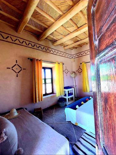 a room with a bed and a couch in a room at Maison d'hôtes IZZA in Kalaat MGouna
