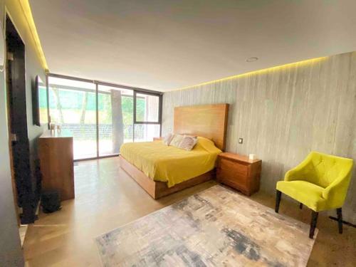 Ciudad López MateosにあるCasa en el bosqueのベッドルーム(黄色のベッド1台、黄色の椅子付)