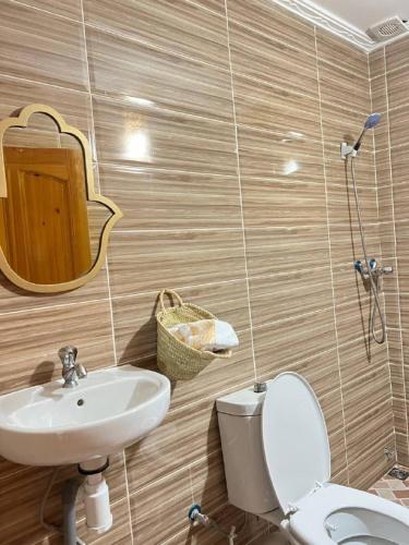 a bathroom with a sink and a toilet and a mirror at rise surf and yoga morocco in Agadir