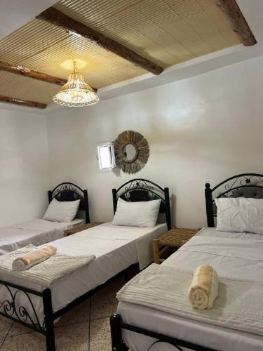 a room with two beds and a chandelier at rise surf and yoga morocco in Agadir