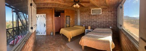 a small room with a bed and a balcony at Baja69 lodge in El Pescadero