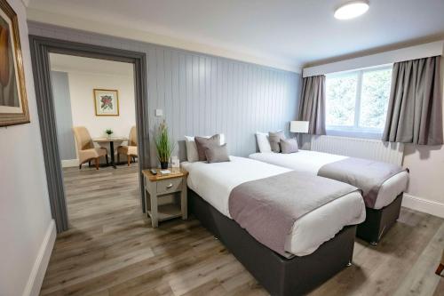 Habitación de hotel con 2 camas y mesa en Best Western Manor Hotel, en Gravesend