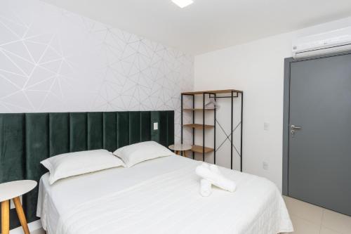 um quarto com uma cama branca e uma parede verde em Apto 750m da UFSC, Sacada com Churrasqueira e Academia FU3431 em Florianópolis