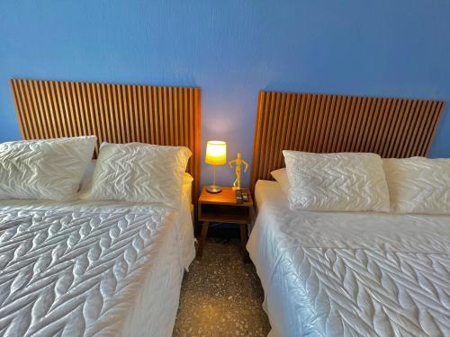 two beds in a room with a lamp on a table at Hotel Citadin Z10 in Guatemala