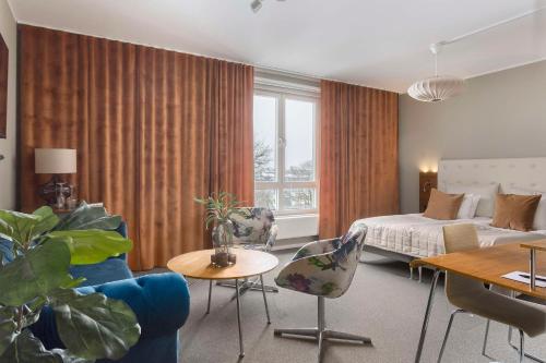um quarto de hotel com uma cama, uma mesa e cadeiras em Best Western Hotel River C em Karlstad