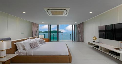 una grande camera da letto con un grande letto e una televisione di Villa Thousand Cliffs a Nai Harn Beach