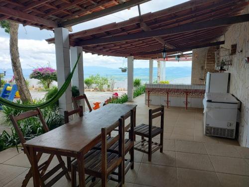 a patio with a table and chairs and a refrigerator at VIVENDA JUAREZ in Viçosa do Ceará