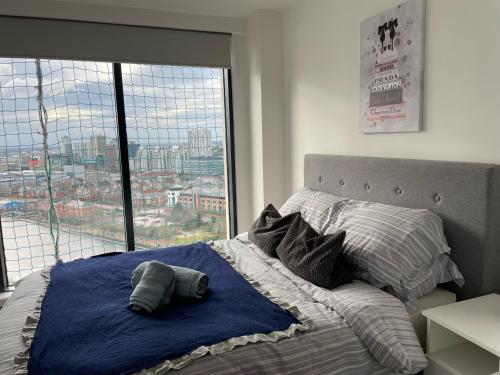 uma cama num quarto com uma grande janela em Quayside Penthouse 2 BedRoom Ensuite near Media City & Manchester United em Manchester