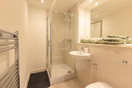 uma casa de banho com um chuveiro, um WC e um lavatório. em Quayside Penthouse 2 BedRoom Ensuite near Media City & Manchester United em Manchester