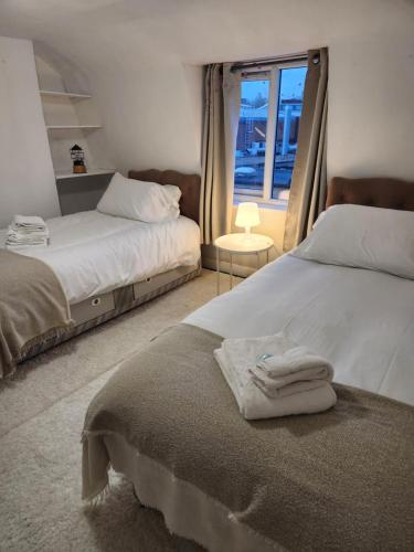a bedroom with two beds with towels on the bed at Oval Cricket Ground walking distance in London