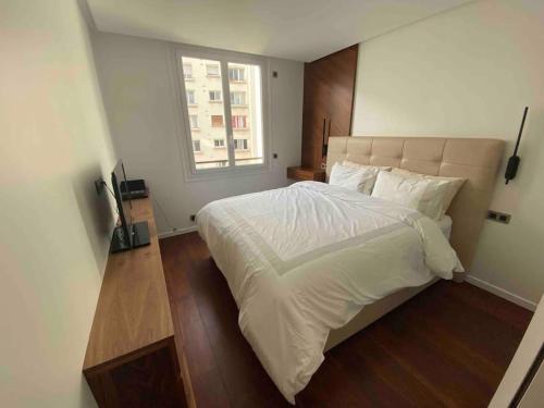 une chambre avec un grand lit blanc avec une fenêtre dans l'établissement Appt River view next Eiffel Tour and Roland-Garros, à Boulogne-Billancourt