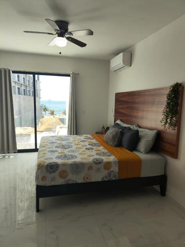 a bedroom with a bed and a ceiling fan at Pent-house a media cuadra del malecón, Hookipa Tower! in Mazatlán