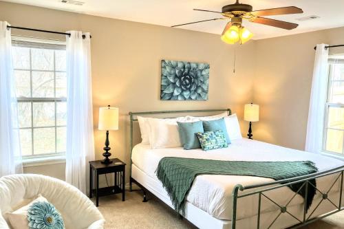a bedroom with a bed and a ceiling fan at Cozy Corner Cottage in Bentonville