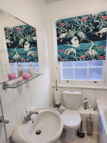 a bathroom with a sink and a toilet and a window at Oval Cricket Ground walking distance in London