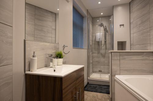 a bathroom with a sink and a shower at The Orange County in Stoke on Trent