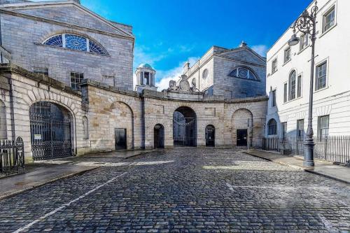 - un grand bâtiment en pierre avec une rue pavée dans l'établissement Munster Suite, 7 Henrietta Street, Dublin 1, à Dublin