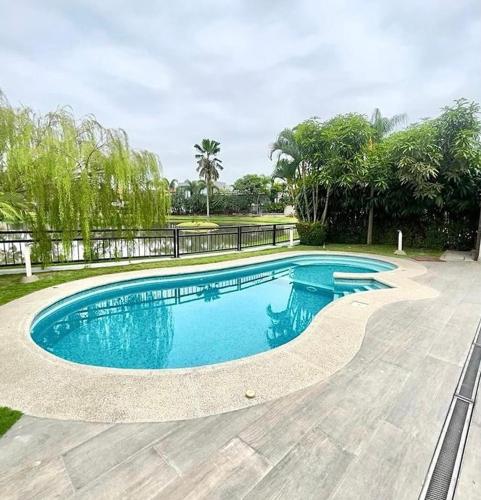 a swimming pool with blue water in a yard at Casa en alquiler en Entre Lagos in Guayaquil