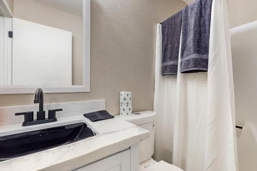 a bathroom with a sink and a mirror at Chandler's Hidden Gem in Chandler